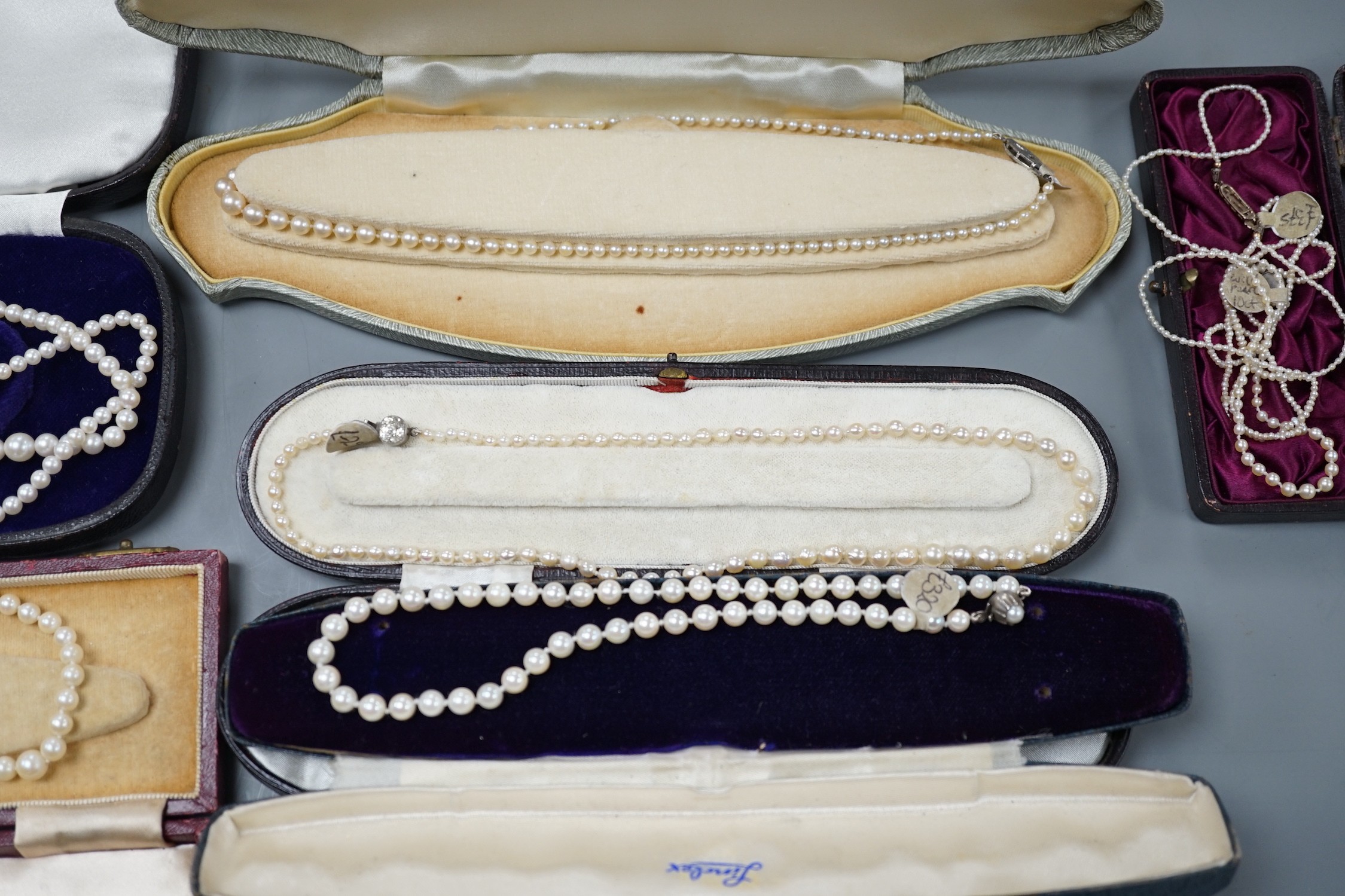 Six assorted single strand graduated cultured pearl necklaces, with marcasite or paste set clasps, longest 64cm and two small seed pearl necklaces, one with rose cut diamond and seed pearl set clasp.